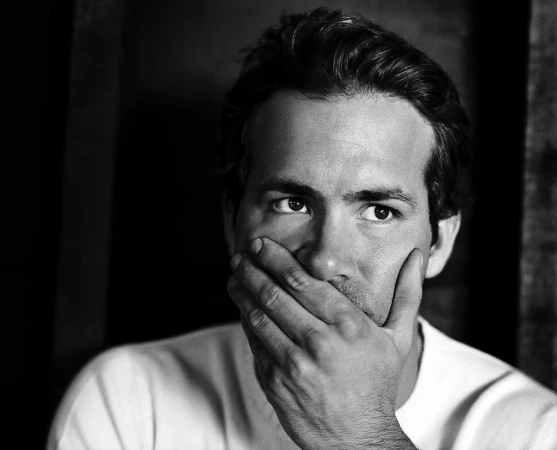 Portrait of Ryan Reynolds with hand over mouth by photographer Jeff Lipsky