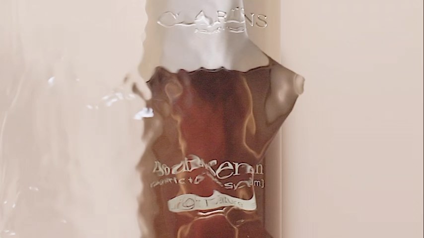 Close-up of Clarins serum bottle in packaging featuring the brand's logo and product name, highlighting beauty product photography.