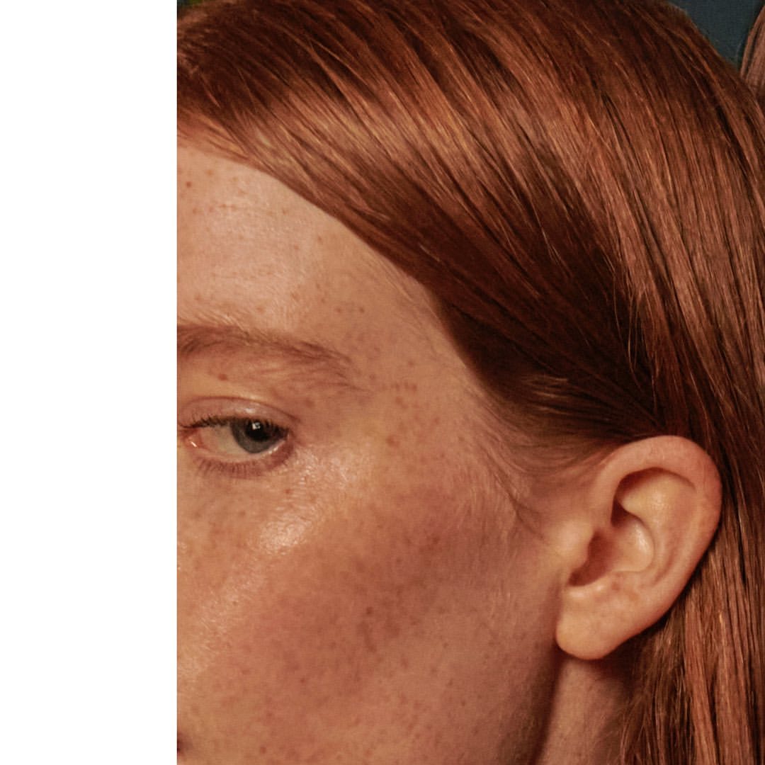 Close-up portrait of a woman with red hair and freckles looking sideways by photographer Jem Mitchell.
