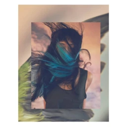 Portrait of a woman with dark hair streaked in turquoise, blowing across her face, captured by photographer Jem Mitchell.