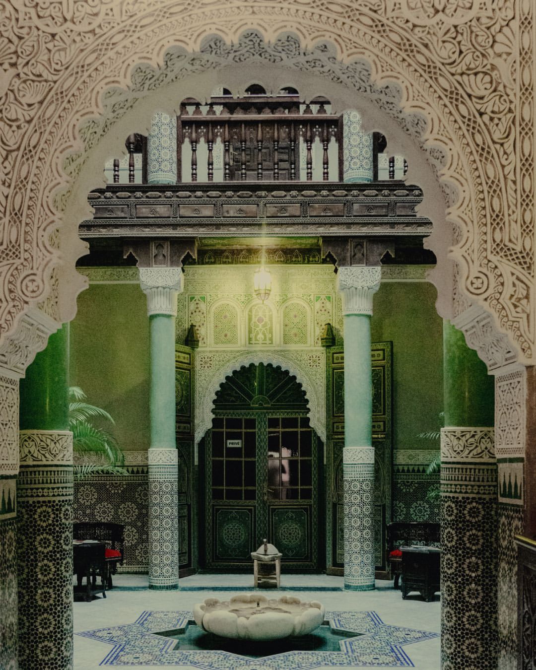 Ornate Moroccan architecture featuring detailed archways, columns, and geometric tilework, creating a sense of depth and intricate design.