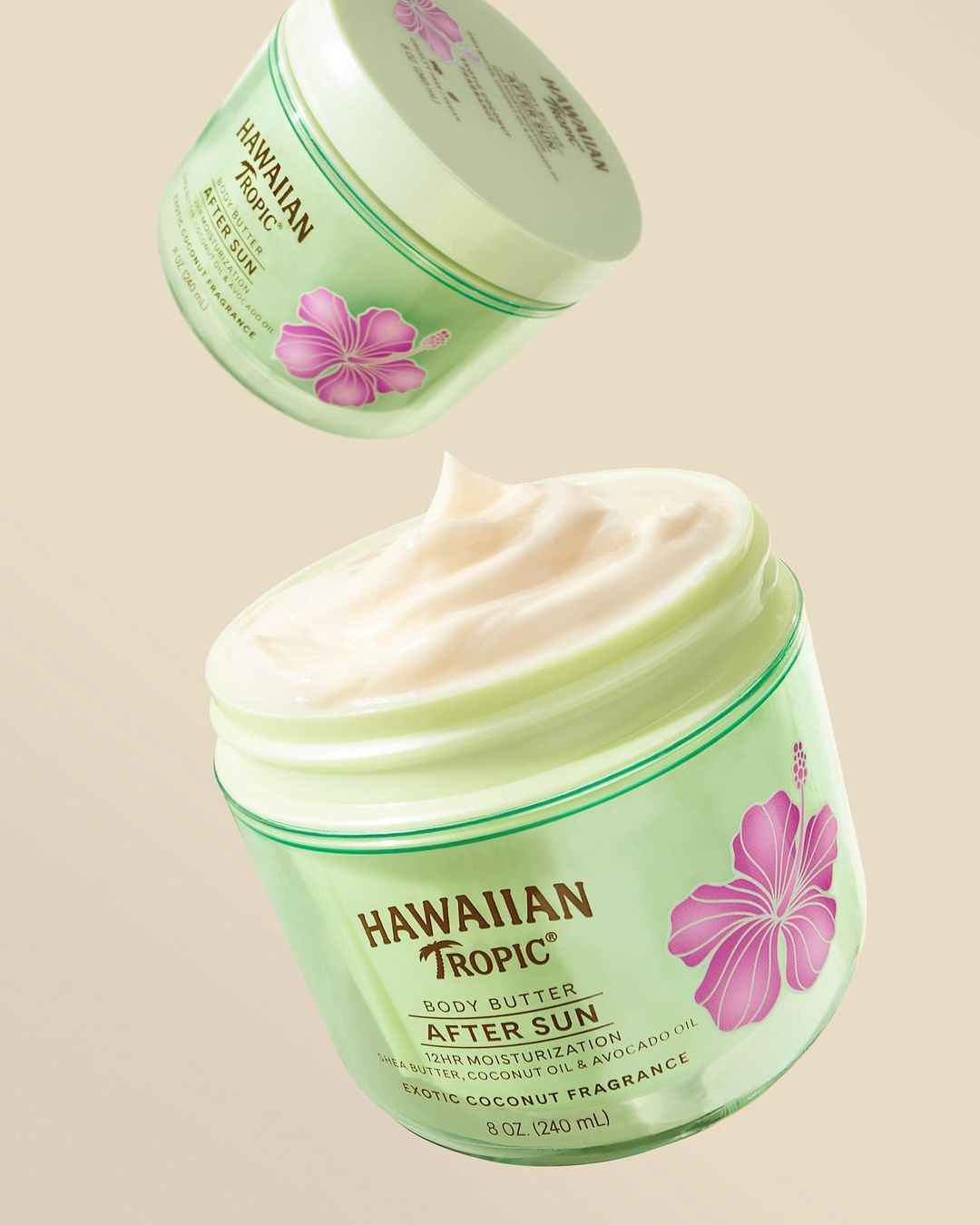 Two jars of Hawaiian Tropic After Sun Body Butter float in front of a neutral background, showcasing the product's creamy texture.