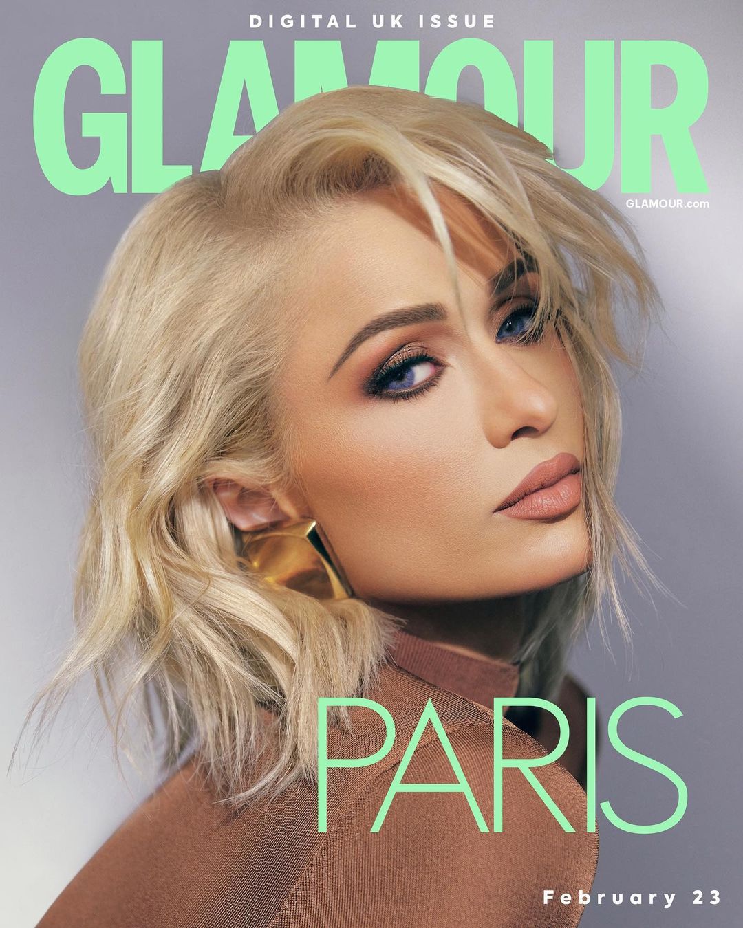 Glamour magazine cover featuring Paris Hilton with blonde hair, wearing a brown top and gold earrings, against a grey backdrop.