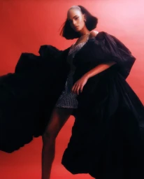Model in a black voluminous gown and sparkling sequin dress against a vivid red background, photographed by Jeremy Choh.