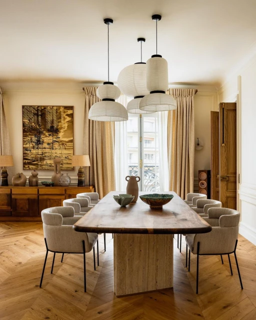 Interior design showcases a dining room with a wooden table, fabric chairs, and unique pendant lights, creating a modern and inviting space.