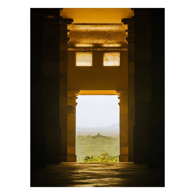 View through classical stone architectural pillars framing a distant misty landscape by Jerome Galland