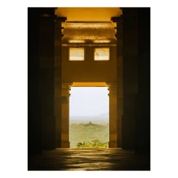 View through classical stone architectural pillars framing a distant misty landscape by Jerome Galland