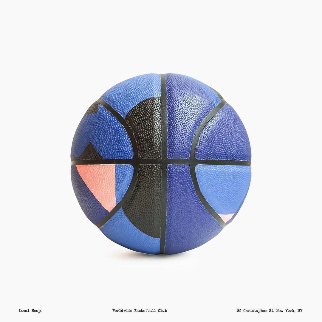 A stylized basketball featuring a geometric color block design in black, blue, and coral against a crisp white background. Studio product shot.