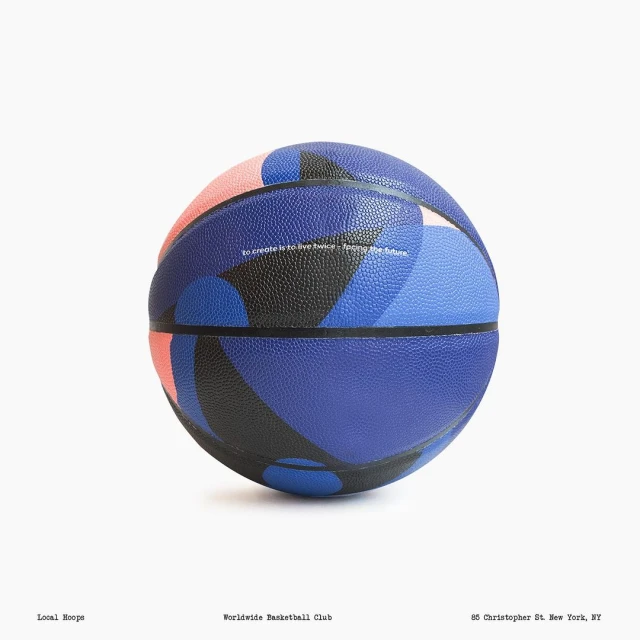 A patterned basketball featuring blue, black, and pink abstract shapes against a clean white seamless studio background.