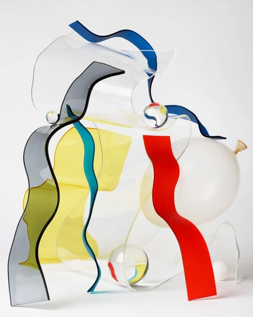 Abstract still life featuring colorful acrylic sheets, clear spheres, and a white balloon against a white background in a studio setting.
