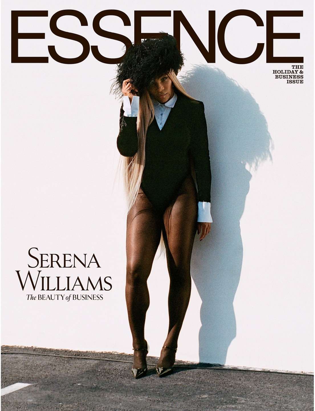 Essence magazine cover featuring Serena Williams in a black bodysuit, feather hat, and black tights, posing against a white wall.
