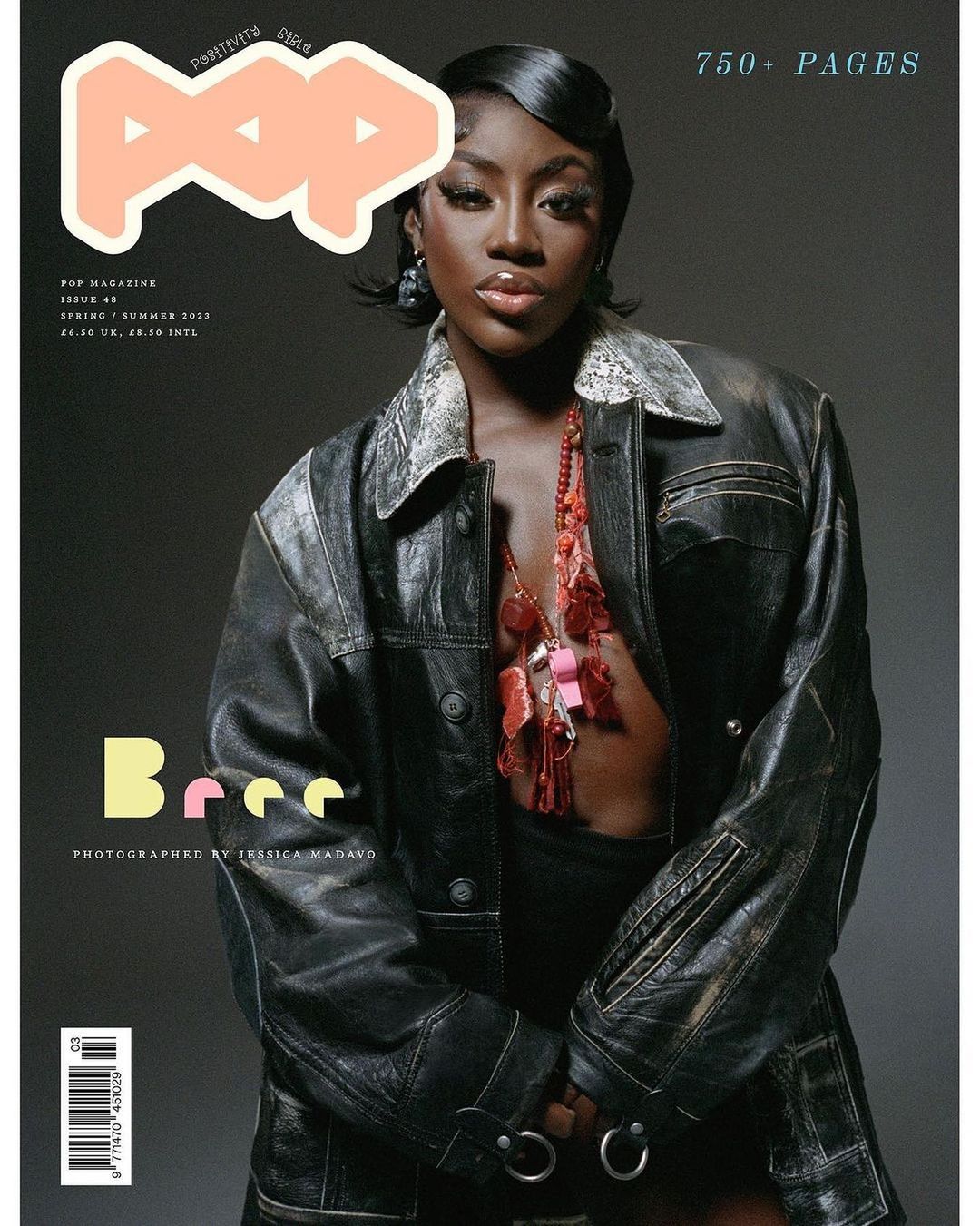 Magazine cover featuring a stylish Black woman in a black leather jacket and coral necklace, set against a subdued grey background.