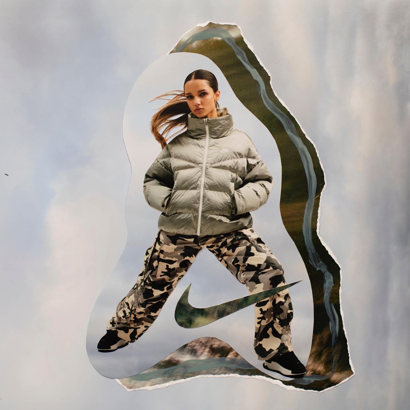 Collage of a woman in a puffer jacket and camo pants with a Nike logo cutout, set against a background of clouds and landscape imagery.