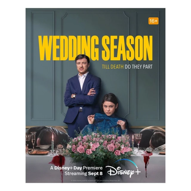Promotional image for 'Wedding Season' on Disney+ with two actors in formalwear seated at a formal table with flower arrangement.