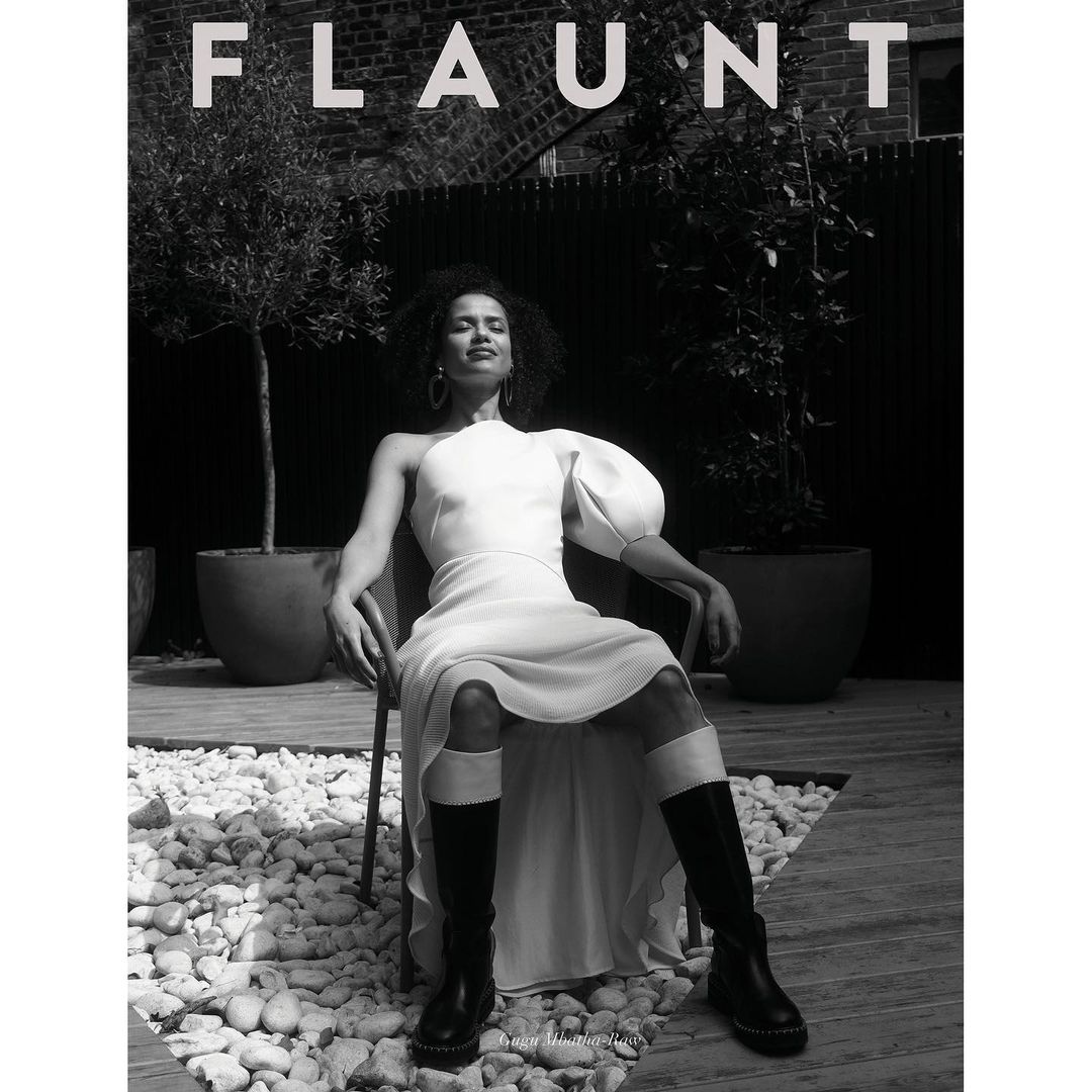 Magazine cover in black and white shows a woman in white dress seated in a chair outside, with the masthead 'Flaunt' visible.