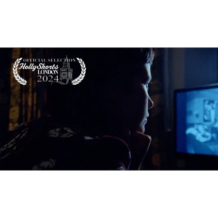 Close-up of a young boy looking at a screen indoors in a dimly lit room, overlaid with a film festival logo, in a dark setting.