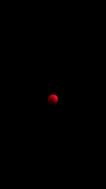 A minimalist image showing a single red sphere centered against a stark black background, creating a high-contrast abstract composition.