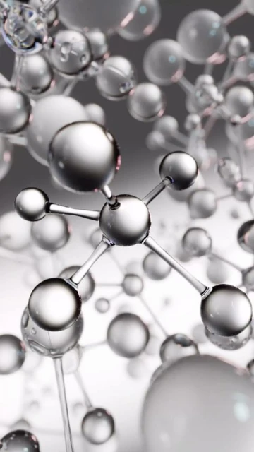 Abstract molecular structure with silver and transparent spheres connected by rods on a blurred gray background.