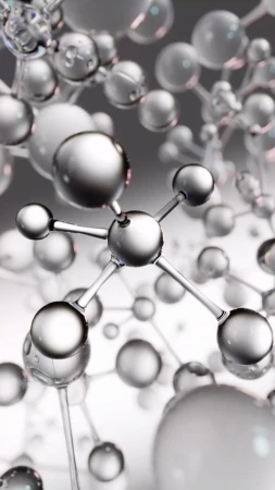 Abstract molecular structure with silver and transparent spheres connected by rods on a blurred gray background.