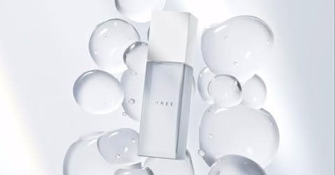 White skincare bottle with a white label and cap. The bottle is surrounded by translucent bubbles on a soft white background.