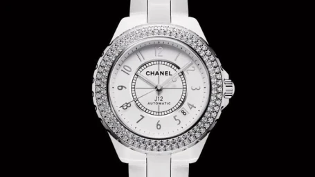 Close-up CGI render of a white ceramic wristwatch with a diamond bezel against a solid black background.
