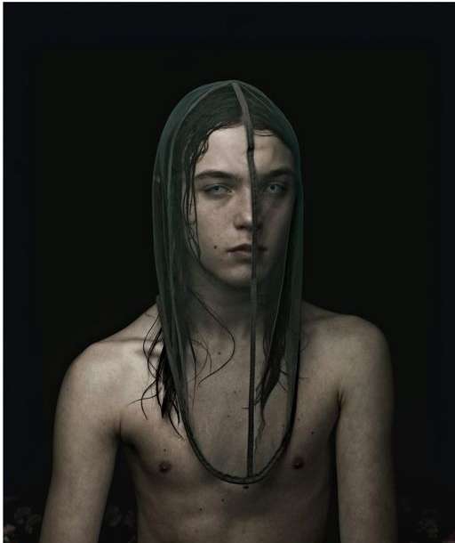 Striking portrait of a young adult with light skin, captured in a studio with dark background, a dark translucent veil covering the head.