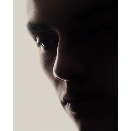 Close-up portrait of a person in deep shadow against a bright white background, highlighting facial contours