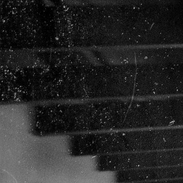 Abstract black and white image featuring horizontal lines, textures, and patterns, creating a visually intriguing monochrome composition.