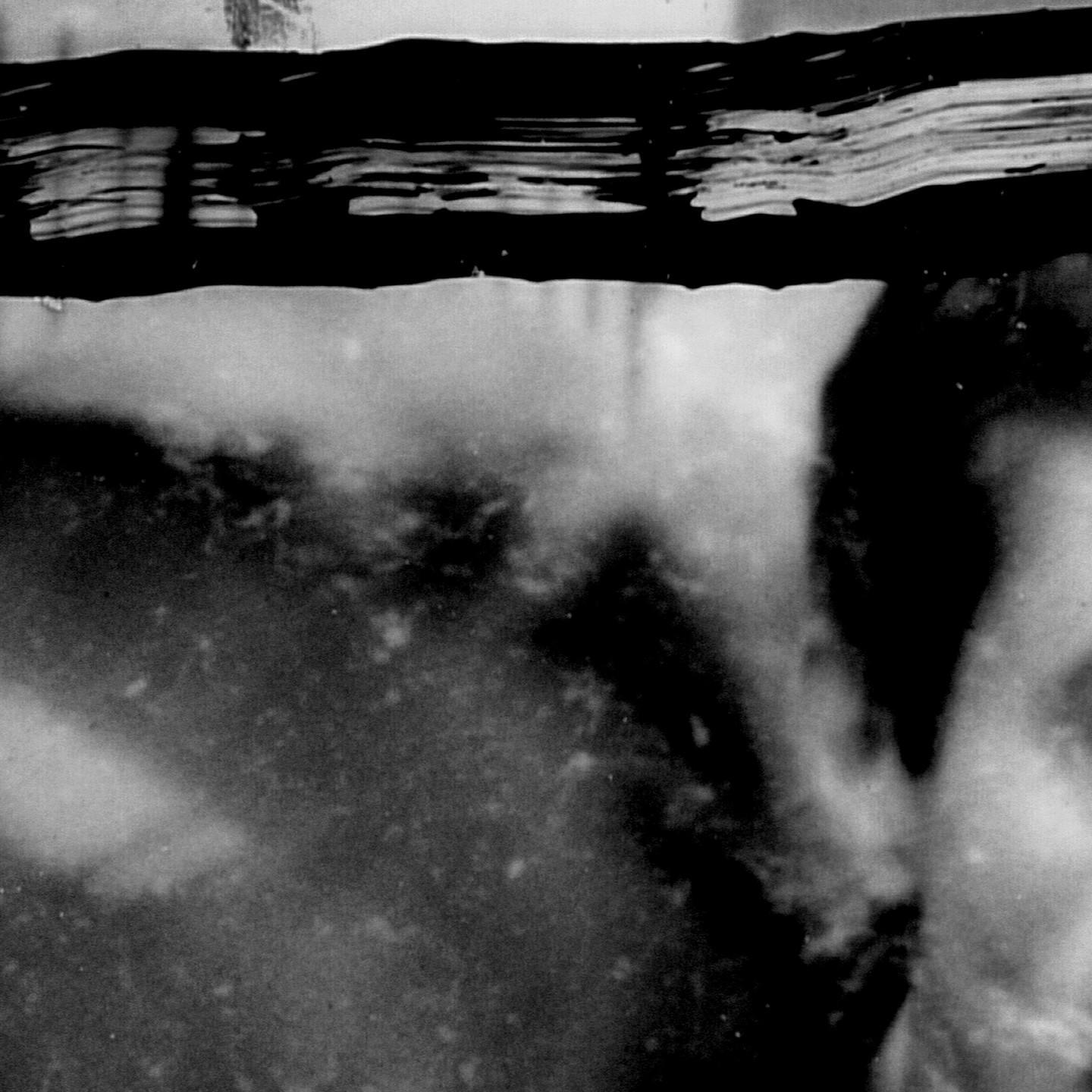 Abstract black and white image featuring dark brush strokes on a light background, creating an interesting contrast with textures.