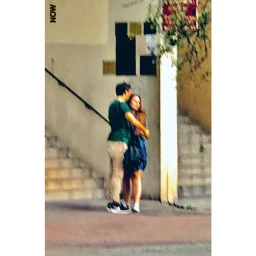 Candid street photograph of a man and woman embracing near outdoor concrete steps in Paris by Jh Engström.