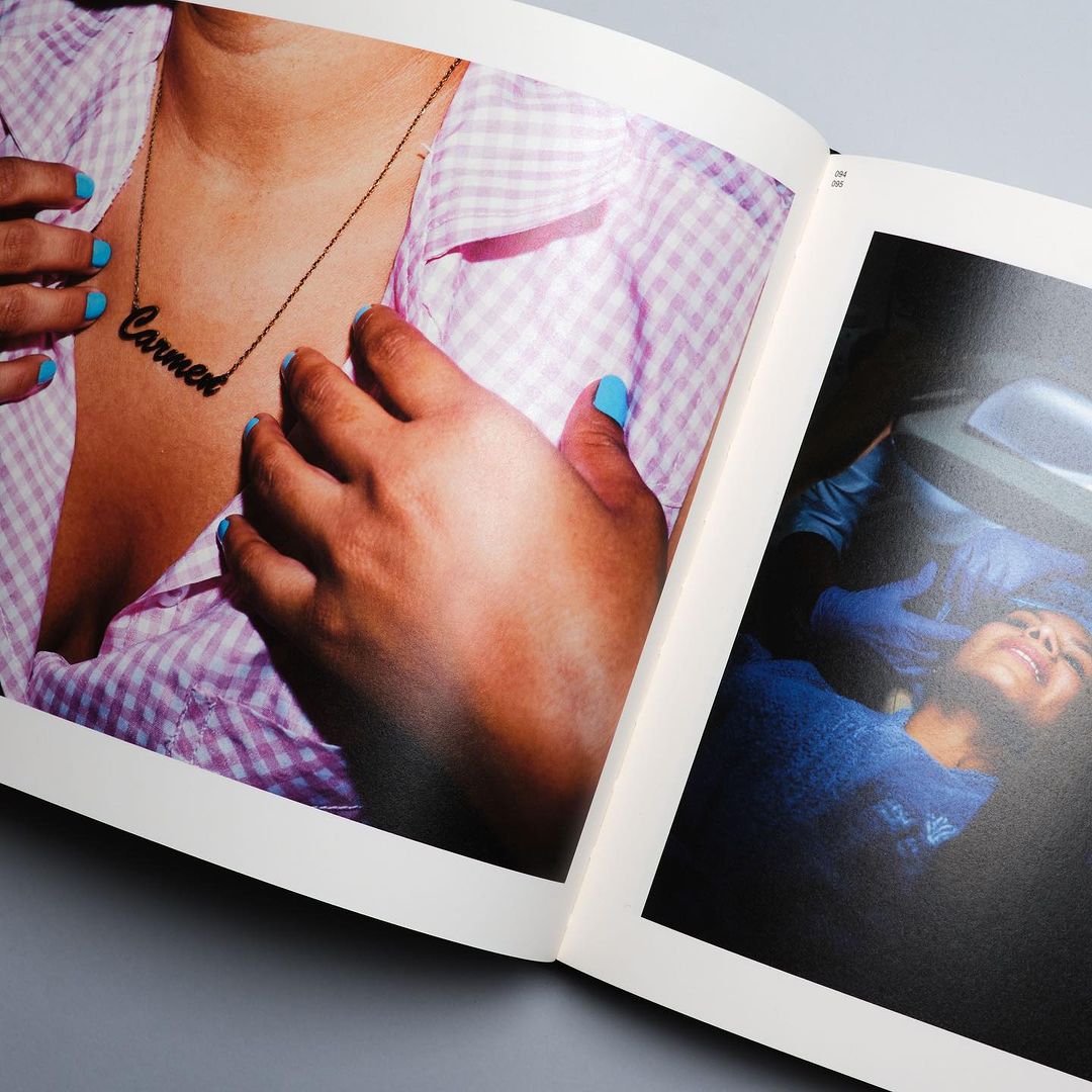An open book features a photograph of a person wearing a necklace with the name Carmen, showcasing fashion and personal expression.