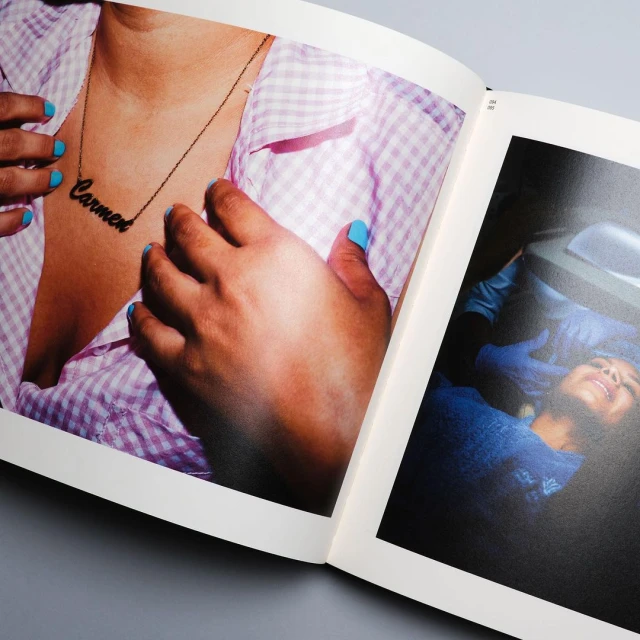 An open book features a photograph of a person wearing a necklace with the name Carmen, showcasing fashion and personal expression.