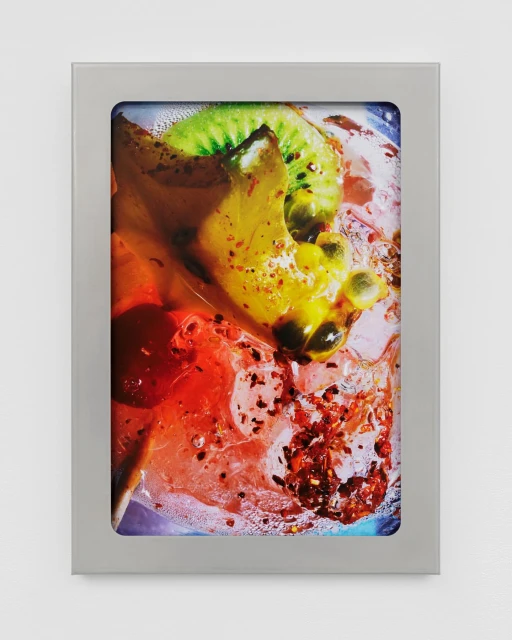 Framed still life photo of kiwi, passion fruit, and mango in a clear liquid. Close-up shot highlighting vibrant colors and fruit textures.