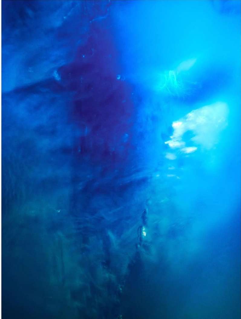 Abstract design with blue and dark blue swirling textures resembling underwater movement and light refraction, creating a fluid aesthetic.