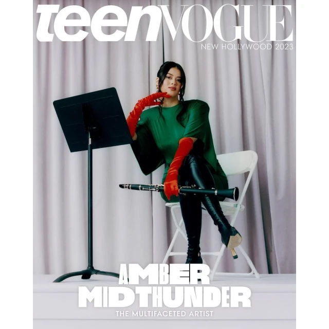 Amber Midthunder poses on a chair, holding a clarinet on the cover of Teen Vogue's New Hollywood 2023 issue, against a curtain backdrop.