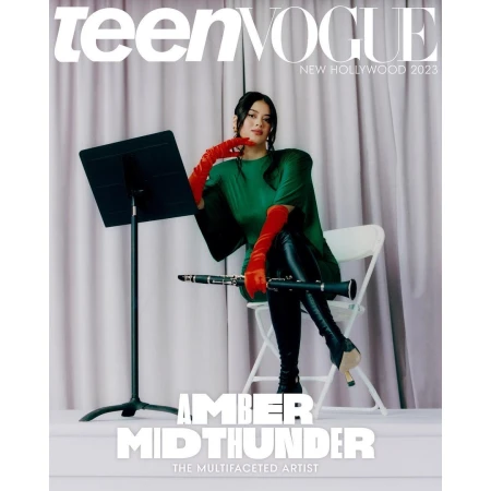 Amber Midthunder poses on a chair, holding a clarinet on the cover of Teen Vogue's New Hollywood 2023 issue, against a curtain backdrop.