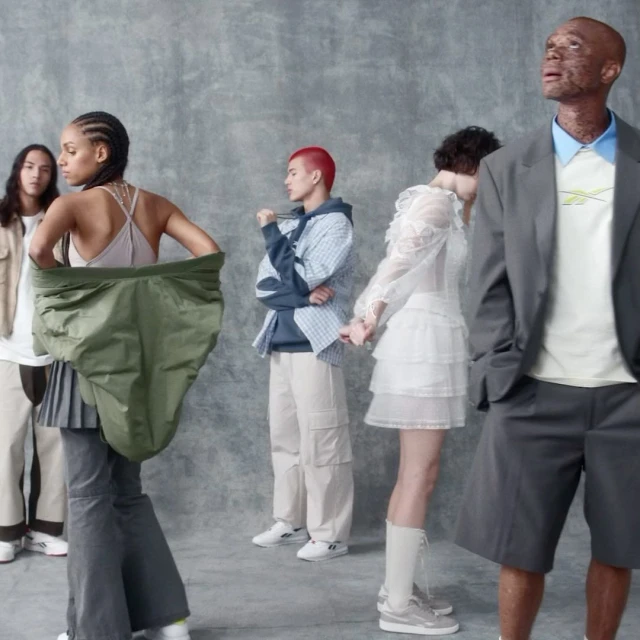 Group of diverse young adult models wearing casual contemporary clothing in a studio setting, posing against a muted gray background.