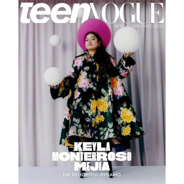 Magazine cover featuring Keyla Monterroso Mejia in a floral coat and hat, holding white spherical objects on a purple backdrop.