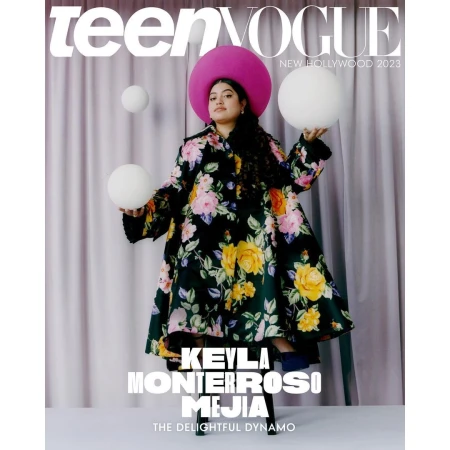 Magazine cover featuring Keyla Monterroso Mejia in a floral coat and hat, holding white spherical objects on a purple backdrop.