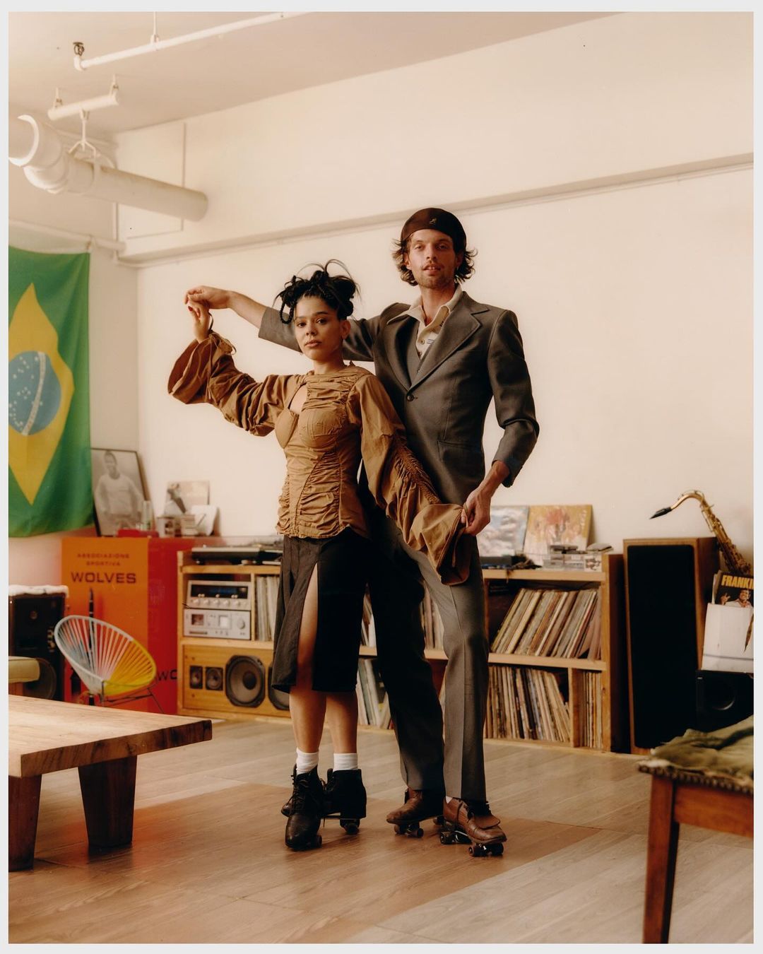 A vintage-style indoor photograph captures a man and woman dancing on roller skates, set against a backdrop of retro decor.