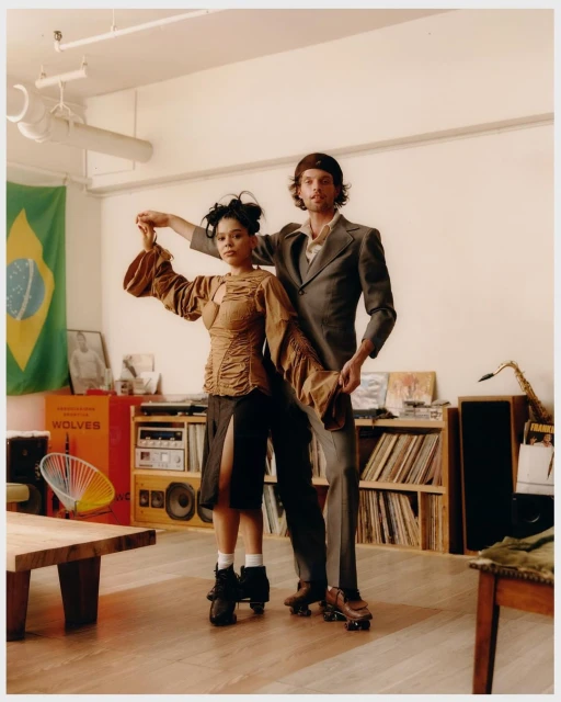 A vintage-style indoor photograph captures a man and woman dancing on roller skates, set against a backdrop of retro decor.