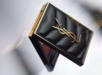 Close-up product shot of a black quilted leather makeup palette with a gold YSL logo by photographer Joana Gauer in Paris.