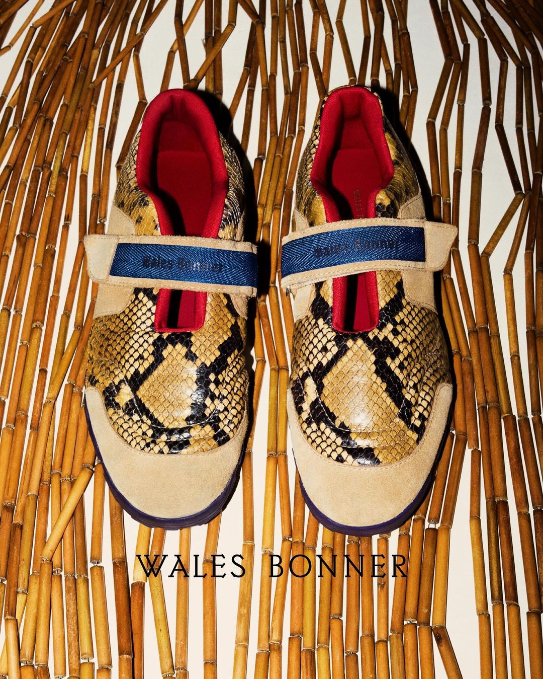 Close-up of tan and snakeskin Wales Bonner shoes on a bamboo surface, showcasing the brand's unique design and texture.