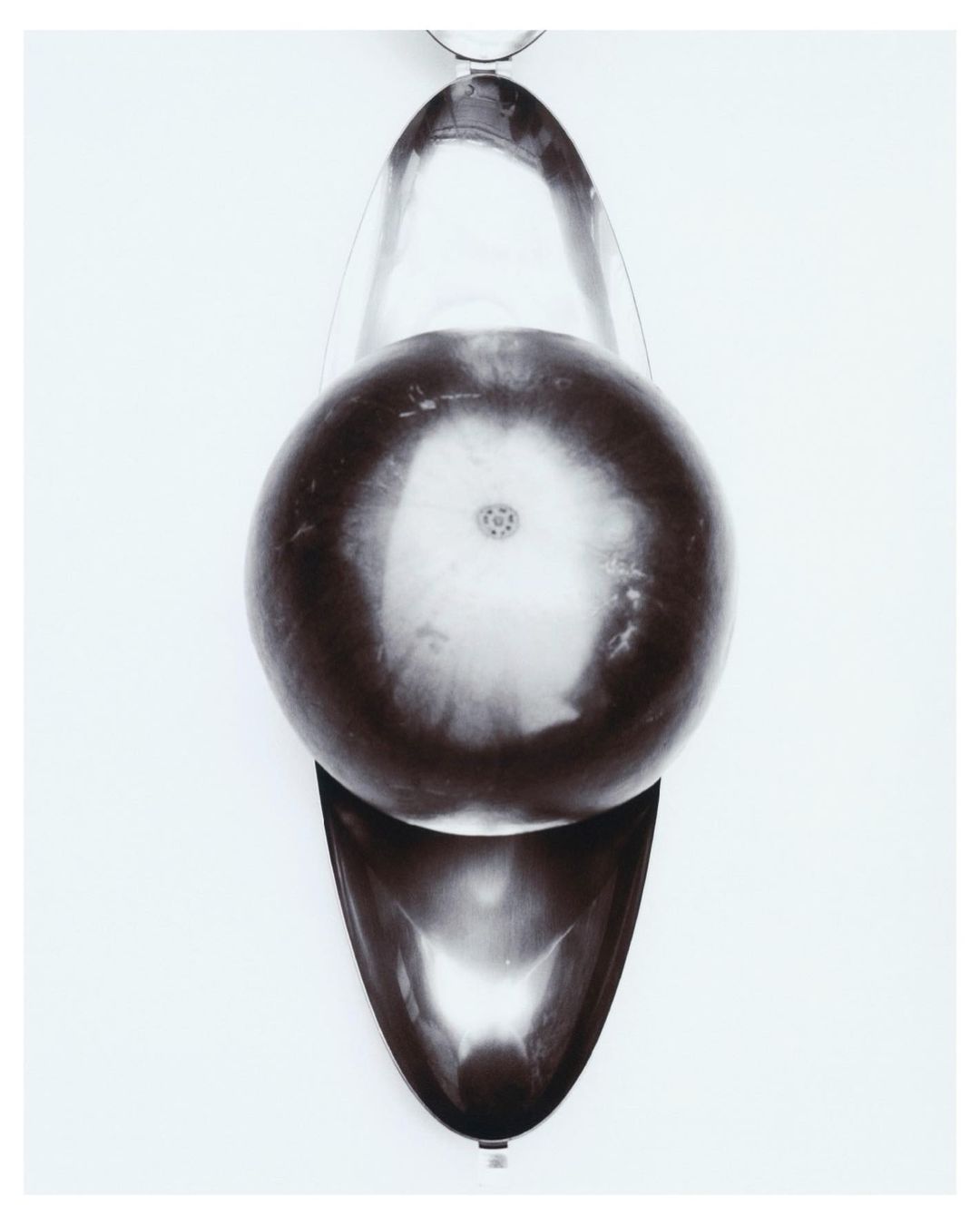 Top-down shot of glass laboratory equipment featuring a round-bottom flask in a pear-shaped mantle on a white background.