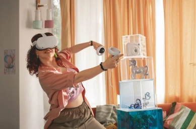 Woman wearing white virtual reality headset and controllers in a living room by photographer Jochen Manz