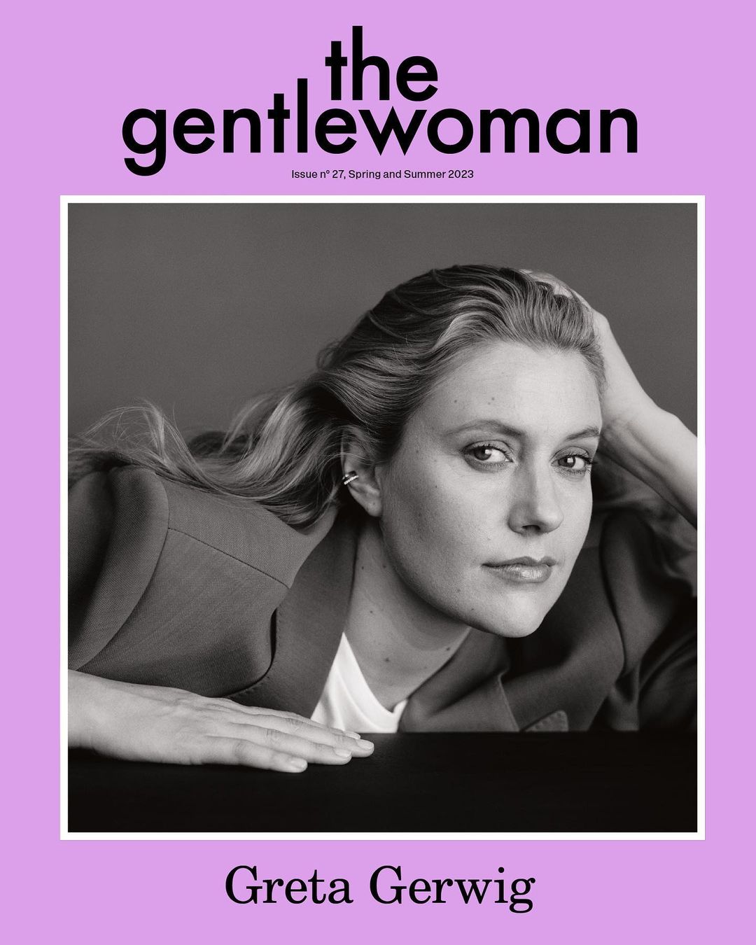 Greta Gerwig poses for The Gentlewoman magazine cover in black and white, wearing a blazer and white shirt, against a grey background.