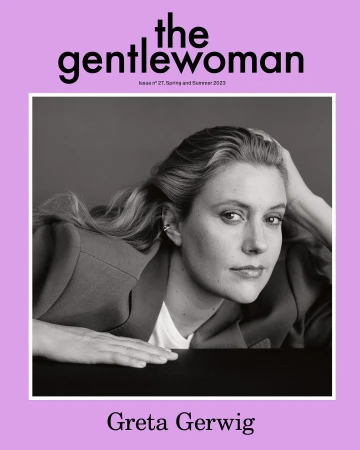 Greta Gerwig poses for The Gentlewoman magazine cover in black and white, wearing a blazer and white shirt, against a grey background.