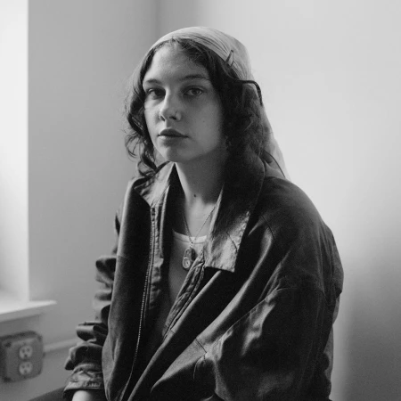 Monochrome portrait of a young woman wearing a leather jacket and a headscarf, photographed by Jody Rogac in New York.