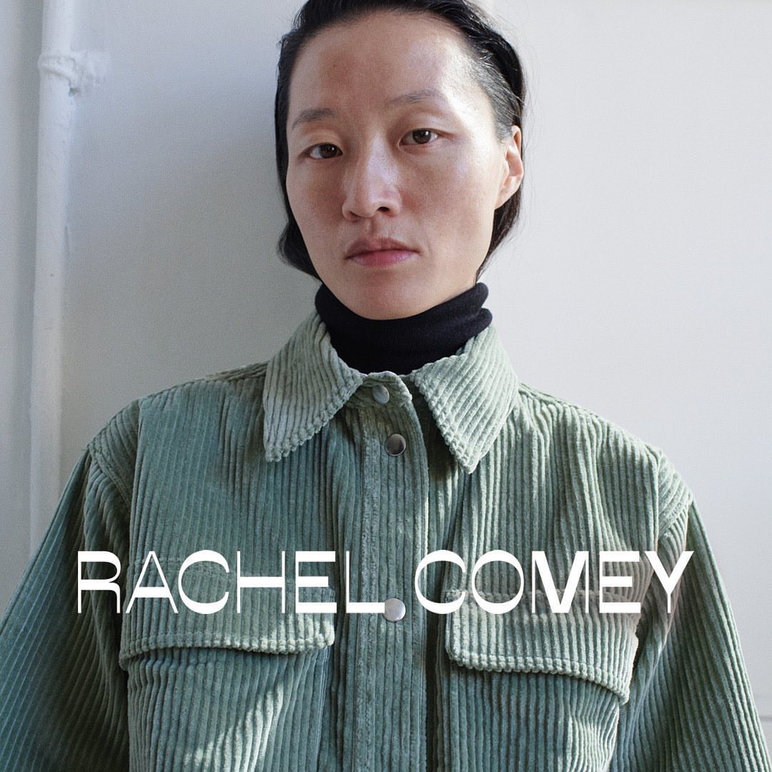 Close-up portrait of an Asian woman in a green corduroy shirt, wearing a black turtleneck against a plain white background.