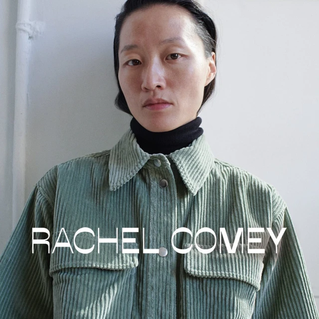Close-up portrait of an Asian woman in a green corduroy shirt, wearing a black turtleneck against a plain white background.